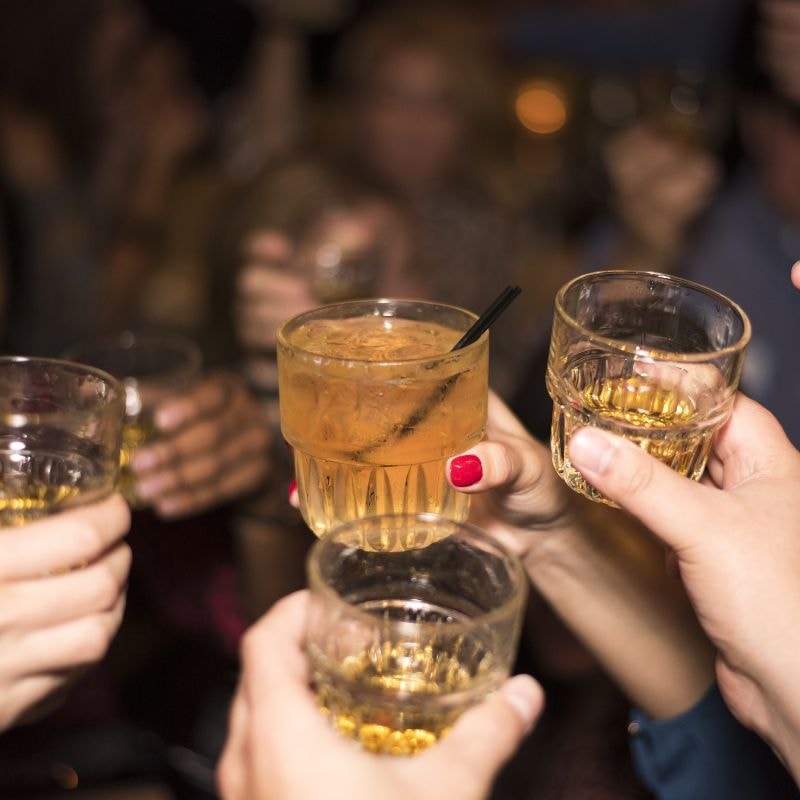 A diverse group of people toasting with glasses of alcohol, celebrating a special occasion together.